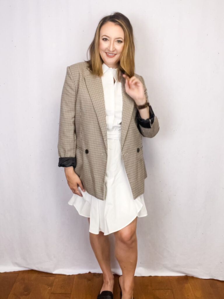 Women wearing white dress with plaid blazer.