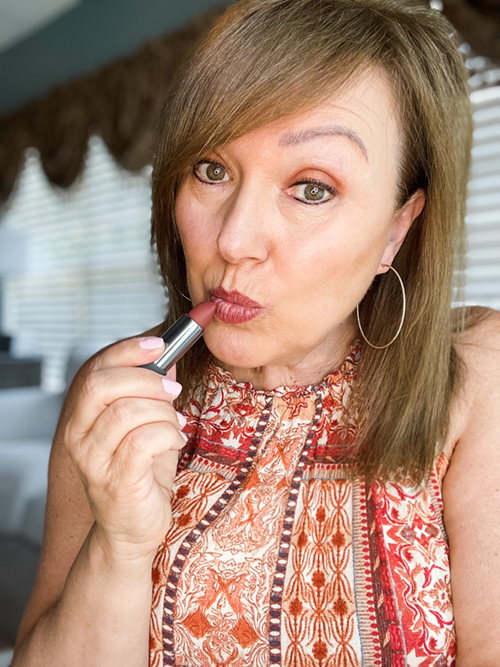 Women putting on clean makeup lipstick.