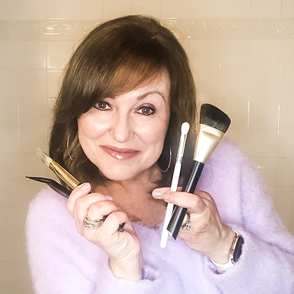 Women holding makeup brushes that need to be cleaned