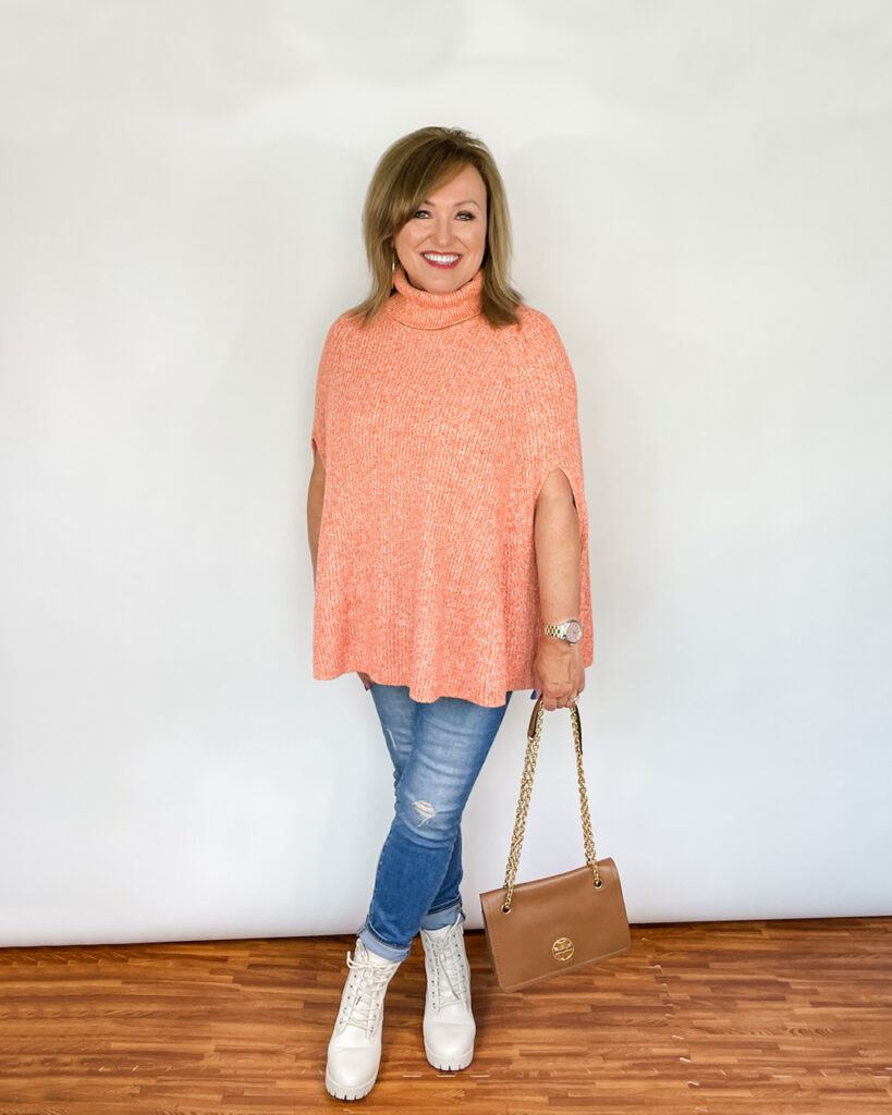 Woman wearing orange cape sweater